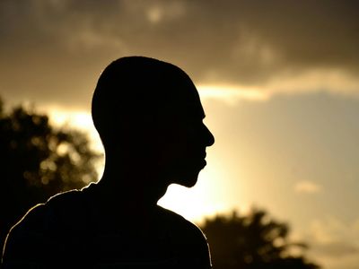 Silhouette of a person balancing against a bright window.